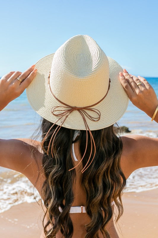 Shophouse Northwest straw panama fedora hat on woman at the beach, woven straw with leather bow tie for sun protection and style