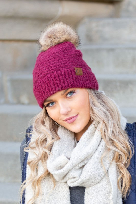 Shophouse Northwest model wearing magenta knit ultra soft fur pom beanie with cream scarf