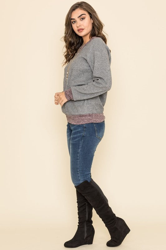 Shophouse Northwest wearing plus size raglan tunic sweater heather gray with mauve hem and black knee high boots