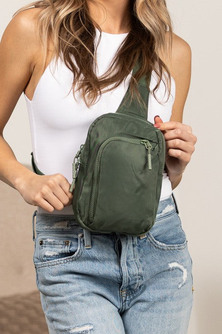 Shophouse Northwest olive green nylon crossbody bag for women worn front with multiple zip pockets and adjustable strap