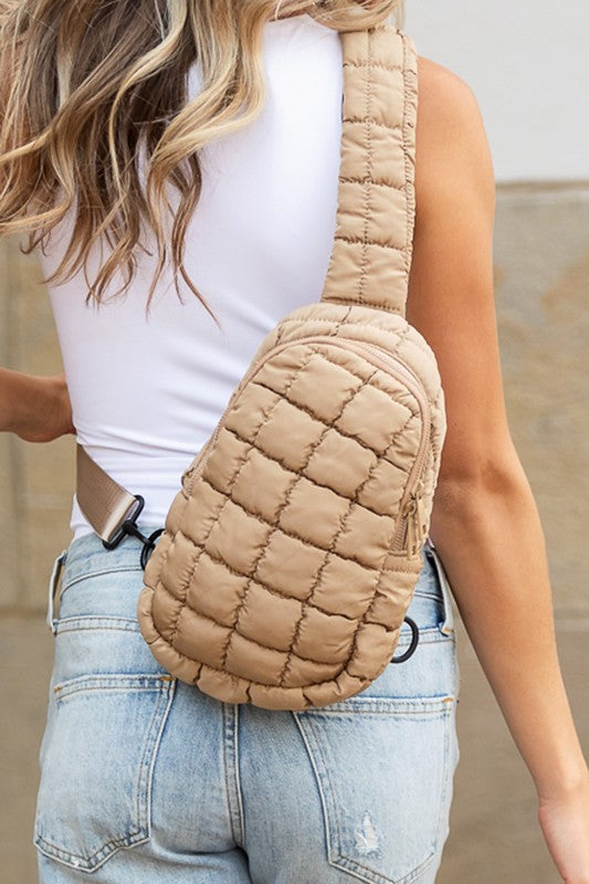 Skyler puffer sling bag tan quilted crossbody worn on back by woman in white tank and light wash jeans