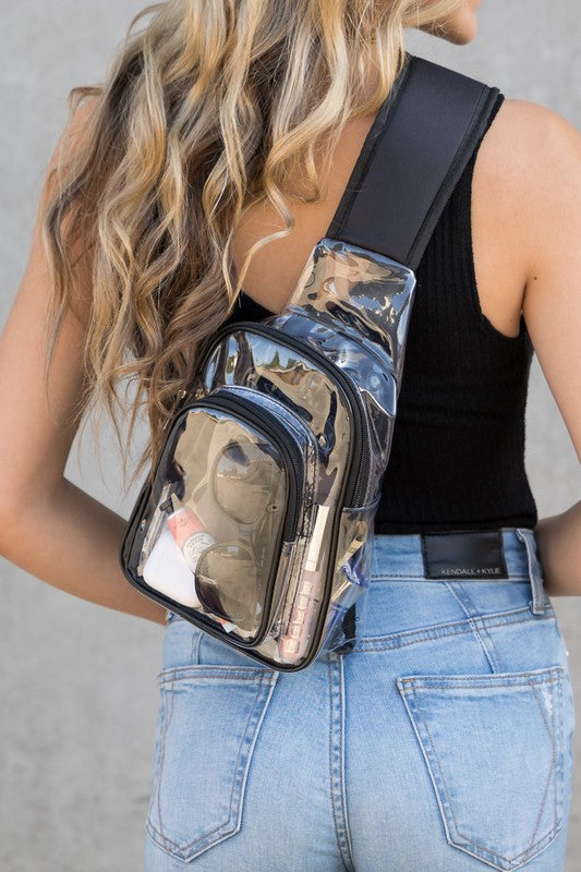 Shophouse Northwest model wearing a clear stadium sling bag with black trim showing sunglasses and phone