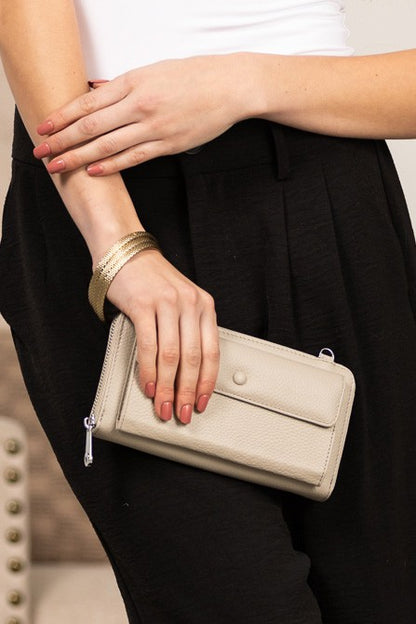 Shophouse Northwest beige wallet clutch held by woman featuring genuine leather phone wallet crossbody with zip closure