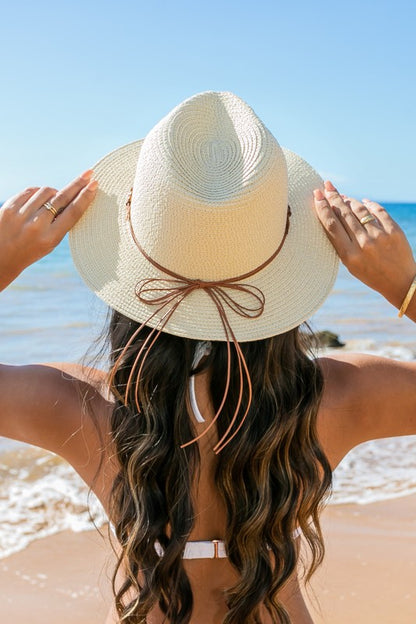 Shophouse Northwest straw panama fedora hat on woman at the beach, woven straw with leather bow tie for sun protection and style