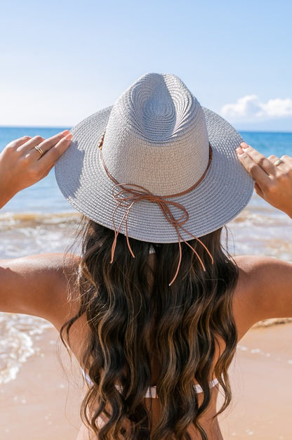 Shophouse Northwest straw panama fedora hat on woman at beach back view with long wavy hair and leather tie