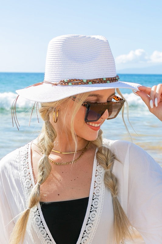 Shophouse Northwest white straw panama fedora hat with beaded band worn by woman at sunny beach