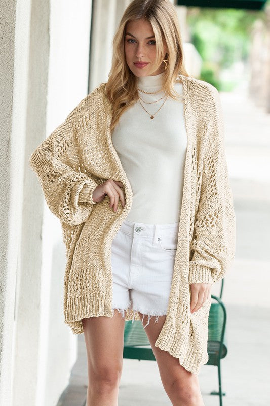 Shophouse Northwest crochet dolman cardigan beige open front chunky knit worn over white turtleneck and denim shorts