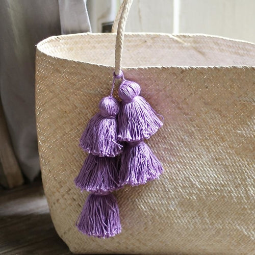 Borneo straw tote bag with decorative purple tassels for stylish summer outings