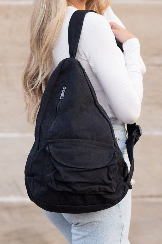Shophouse Northwest black oversized canvas sling bag worn crossbody by woman with front zip pocket for daily use