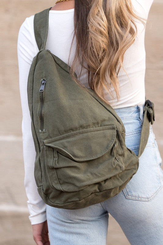 Shophouse Northwest oversized canvas sling bag in olive with multiple pockets worn crossbody