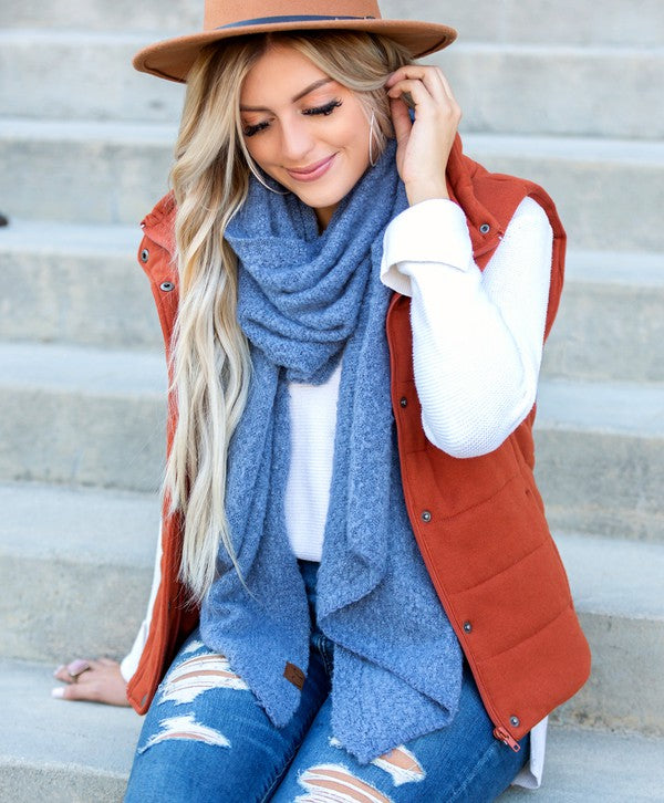 Model wearing a blue cc cozy draped oversized scarves for women styled with rust vest hat ripped jeans
