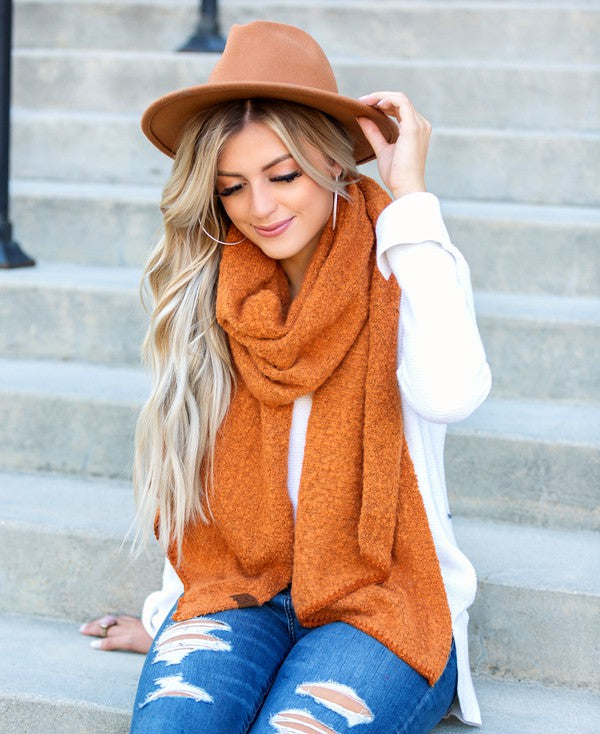 Shophouse Northwest model wearing cc cozy draped oversized scarves for women in rust orange on steps