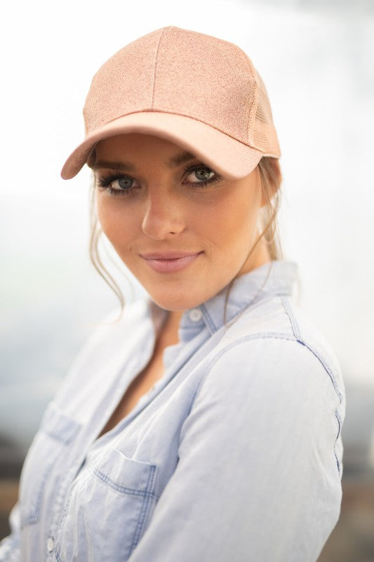 Woman wearing Shophouse Northwest CC glitter messy bun hat in blush pink with mesh back and curved brim