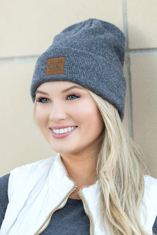 Smiling woman wearing gray knit CC heathered boyfriend beanie with leather CC patch casual winter style