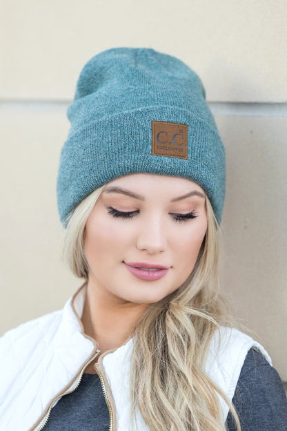 Model wearing teal CC heathered boyfriend beanie with leather logo patch by Shophouse Northwest