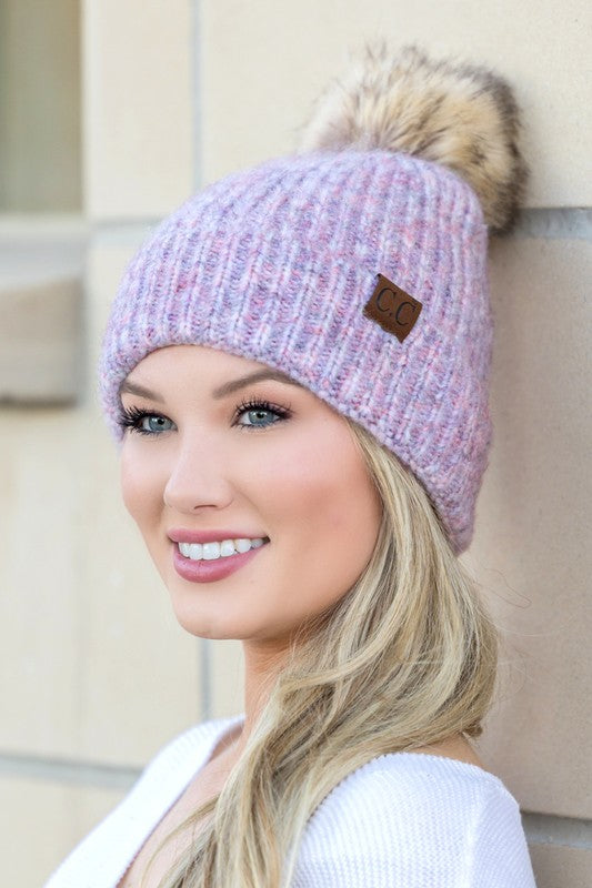 CC marled pom beanie on smiling woman in lavender knit with faux fur pom and CC leather patch