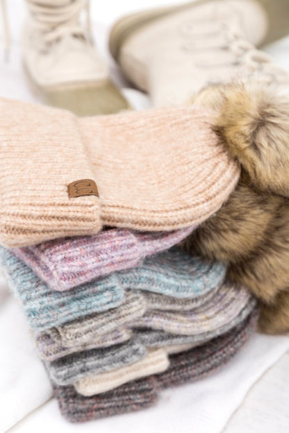 Stack of Shophouse Northwest CC marled pom beanie in neutral marled colors with faux fur pom and boots