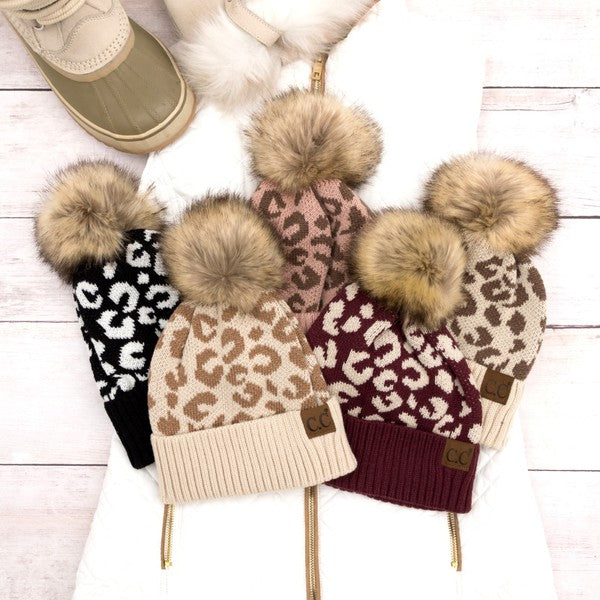Shophouse Northwest leopard fur knit pom beanie . Assorted leopard knit beanies with faux fur pom in black tan burgundy cream