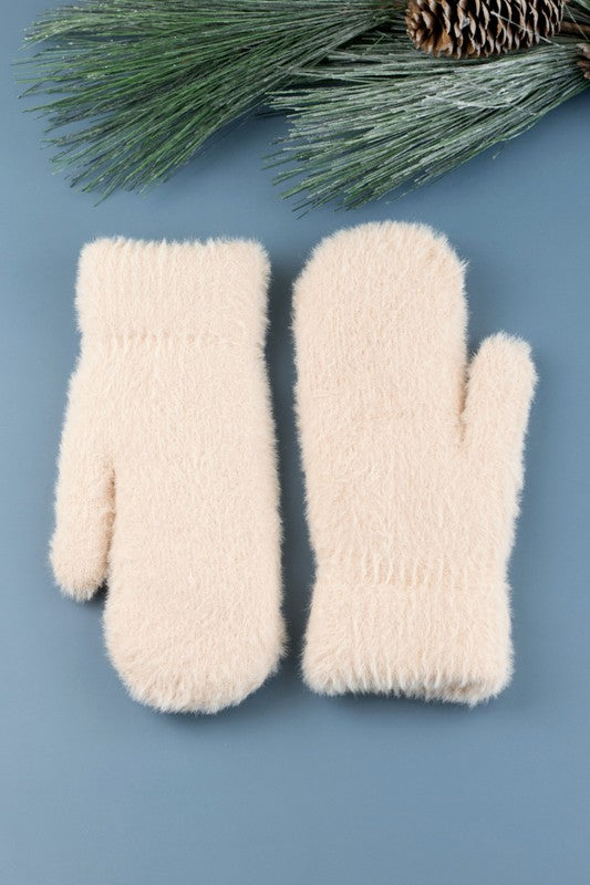 Shophouse Northwest cream fuzzy winter plush fur lined mittens on blue background with pine sprig