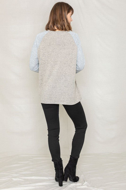 Shophouse Northwest sweater back view on model wearing a plus size two tone raglan tunic in beige and light blue