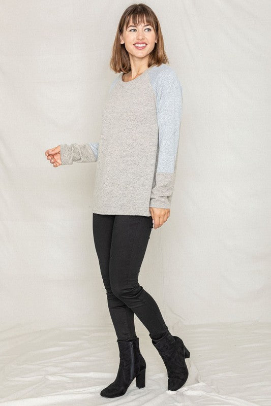 plus size two tone raglan tunic sweater in heather gray with light blue sleeves shown with black jeans and boots