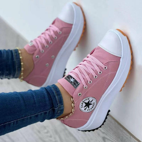 Pink flat lace-up canvas sneakers with white toe caps and a stylish design for casual wear
