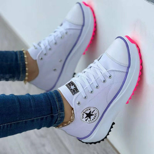 Stylish flat lace-up canvas sneakers featuring neon soles for a trendy look