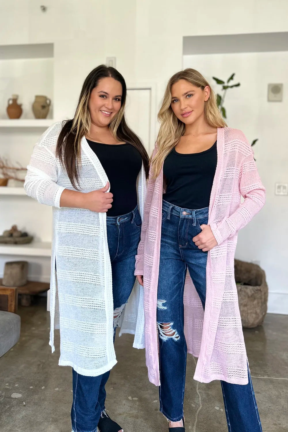 Two women modeling full size cardigan sweater in white and pink, paired with jeans and tank tops