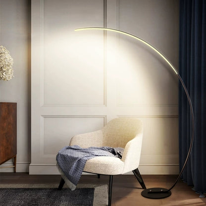 Modern curve floor lamp elegantly illuminating a cozy reading nook beside a stylish armchair
