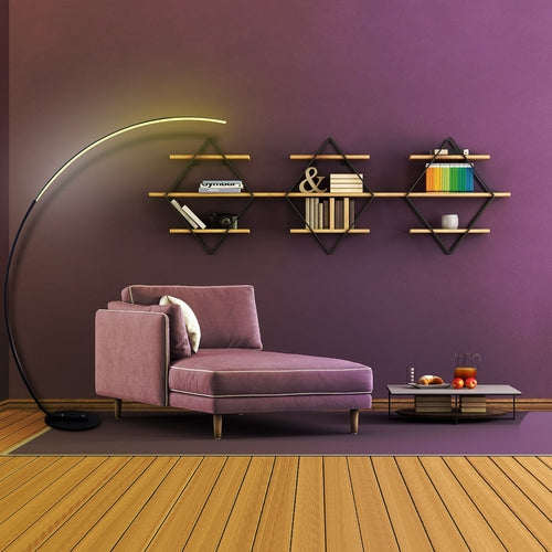 Modern curve floor lamp beside a cozy purple armchair in a stylish interior setting