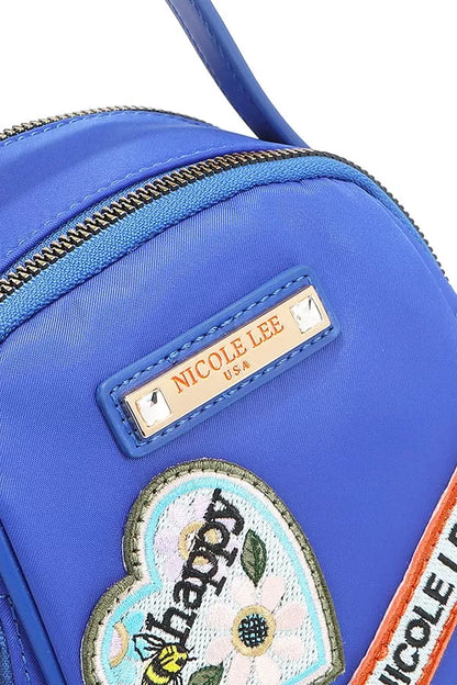 Close-up view of the Nicole Lee color patch bag showcasing bright blue fabric and playful patches
