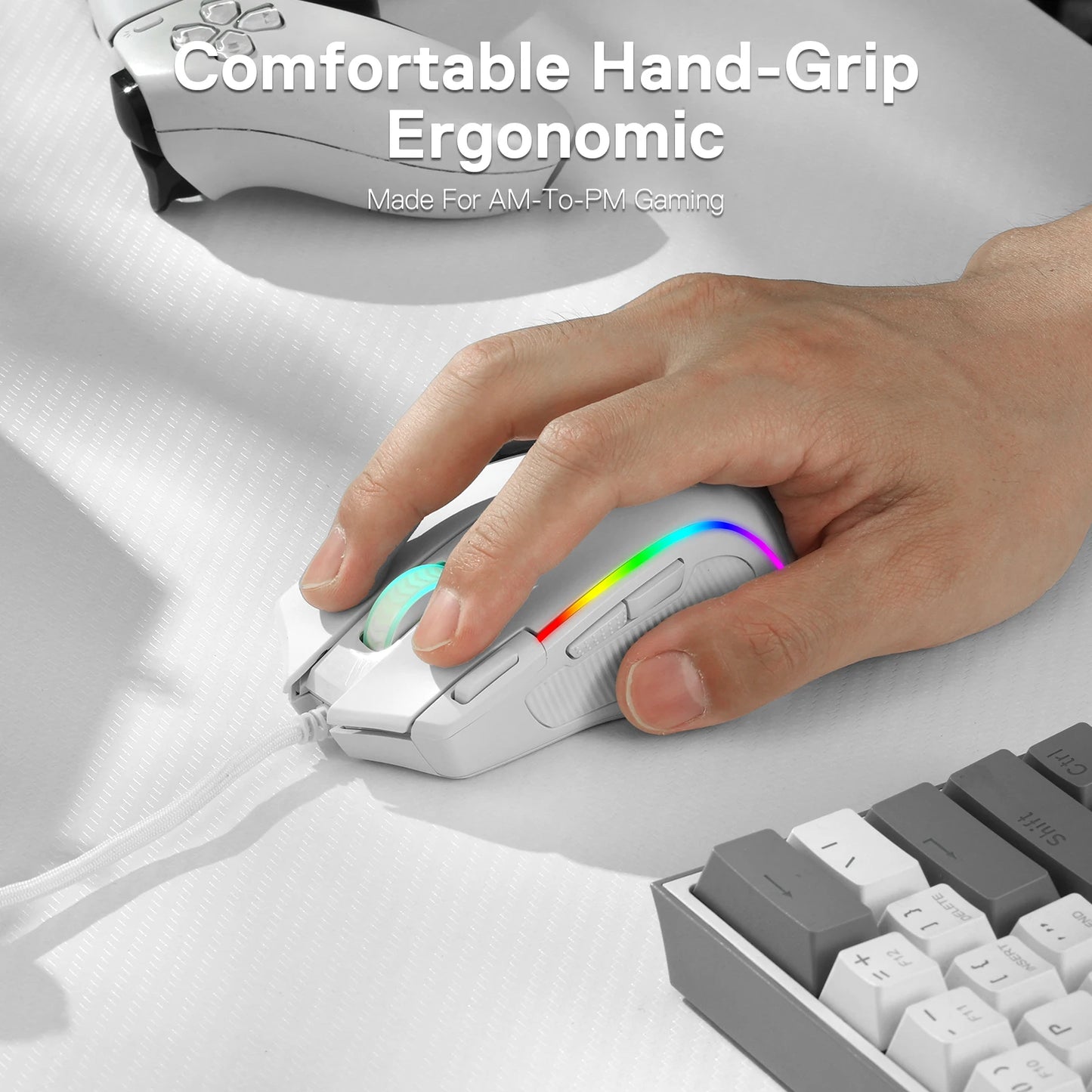 Hand gripping white Redragon M612 Predator gaming mouse with RGB lighting and braided cable on white desk near keyboard