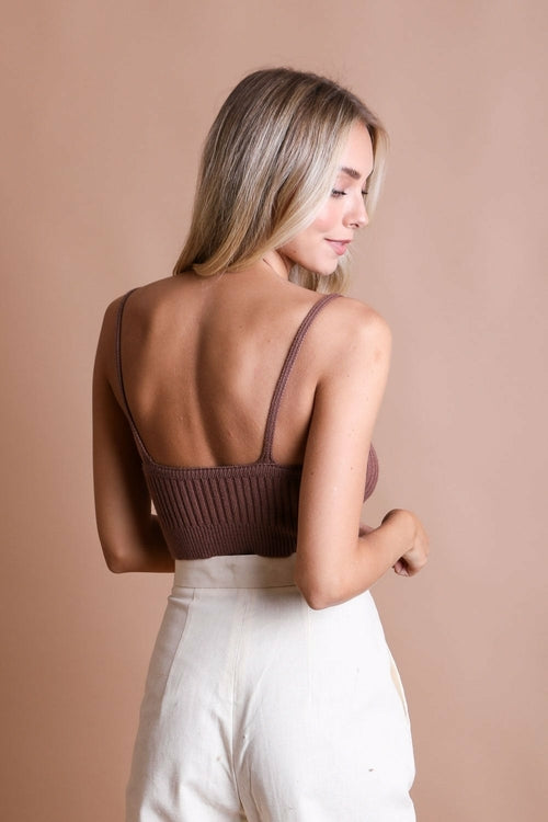 Back view of a model wearing a ribbed cropped cami top in brown, paired with light-colored pants