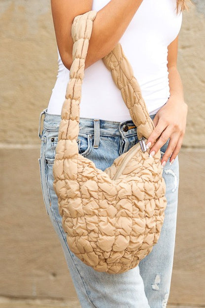 Shophouse Northwest beige quilted puffer shoulder bag with ruched texture and padded strap worn crossbody