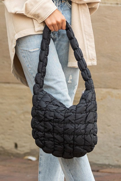 Shophouse Northwest black quilted puffer shoulder bag with braided padded strap worn with jeans