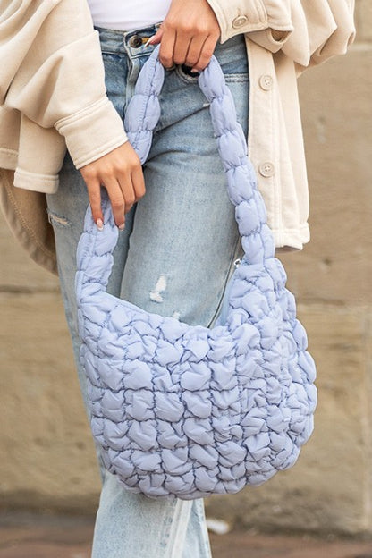 Shophouse Northwest light lavender quilted puffer shoulder bag with braided strap worn with jeans