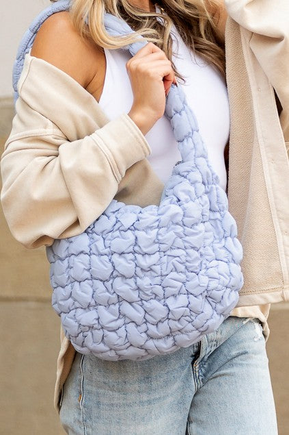 Shophouse Northwest light blue quilted puffer shoulder bag with braided strap and soft quilted texture