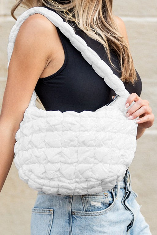 Shophouse Northwest white quilted puffer shoulder bag with braided padded strap worn casually