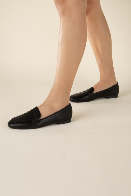Shophouse Northwest black leather Harriet-8 slip on penny flats shoes shown on model feet with low heel