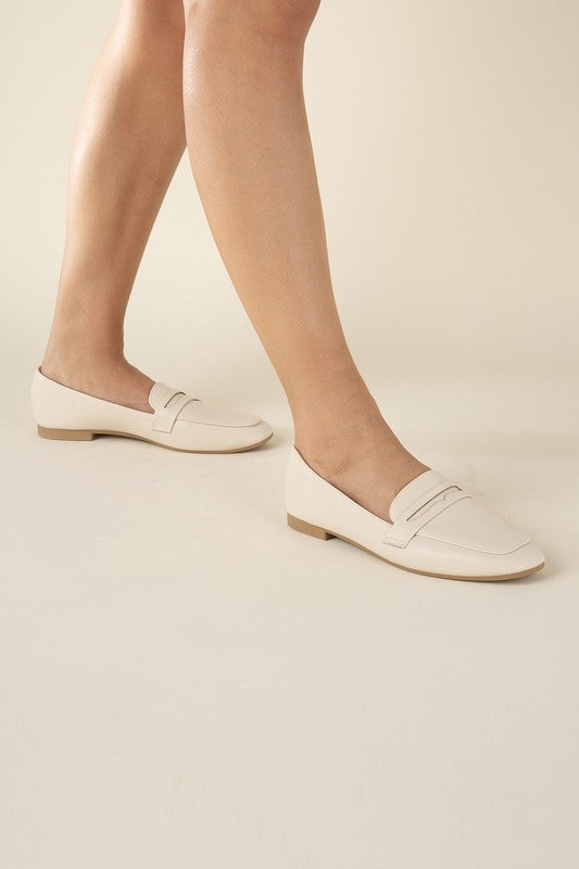 Shophouse Northwest Harriet-8 slip on penny flats shoes in cream leather worn on model feet