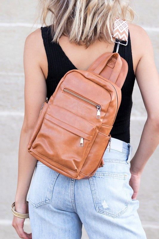 Casual woman wearing tan leather Alba backpack sling convertible bag crossbody with patterned strap for daily travel