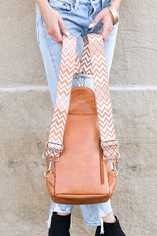 Alba backpack sling convertible bag tan leather with chevron patterned straps held by woman in jeans