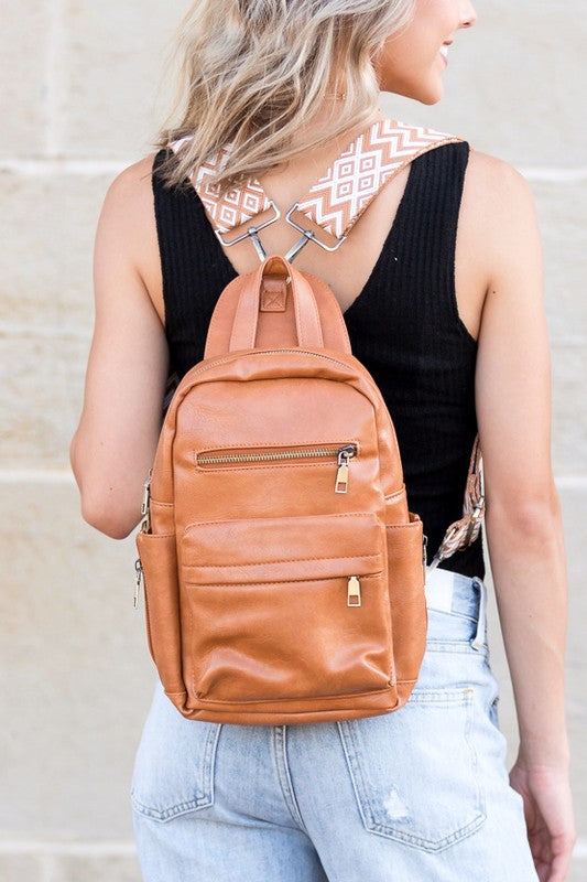 Alba backpack sling convertible bag by Shophouse Northwest tan leather backpack worn crossbody with patterned strap