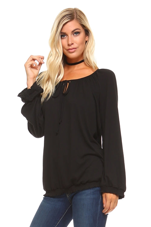 Model wearing a black women's long sleeve peasant top with tie neck and ruffled cuffs